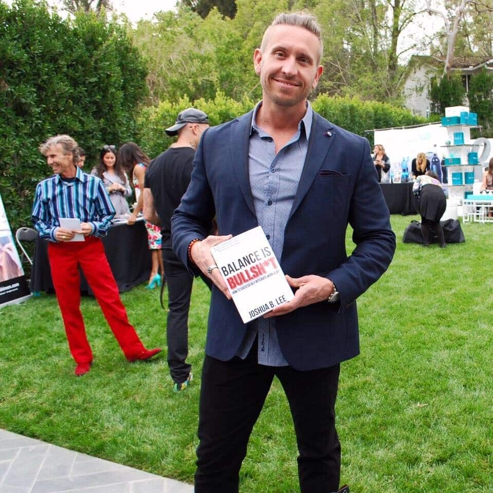 Joshua holding his book "Balance is Bullsh*t"